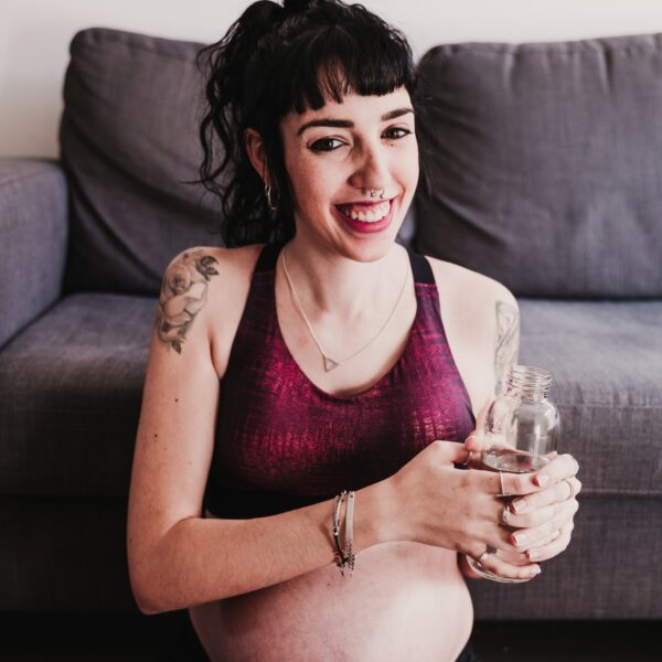 young pregnant woman at home practicing yoga sport and drinking water, healthy lifestyle