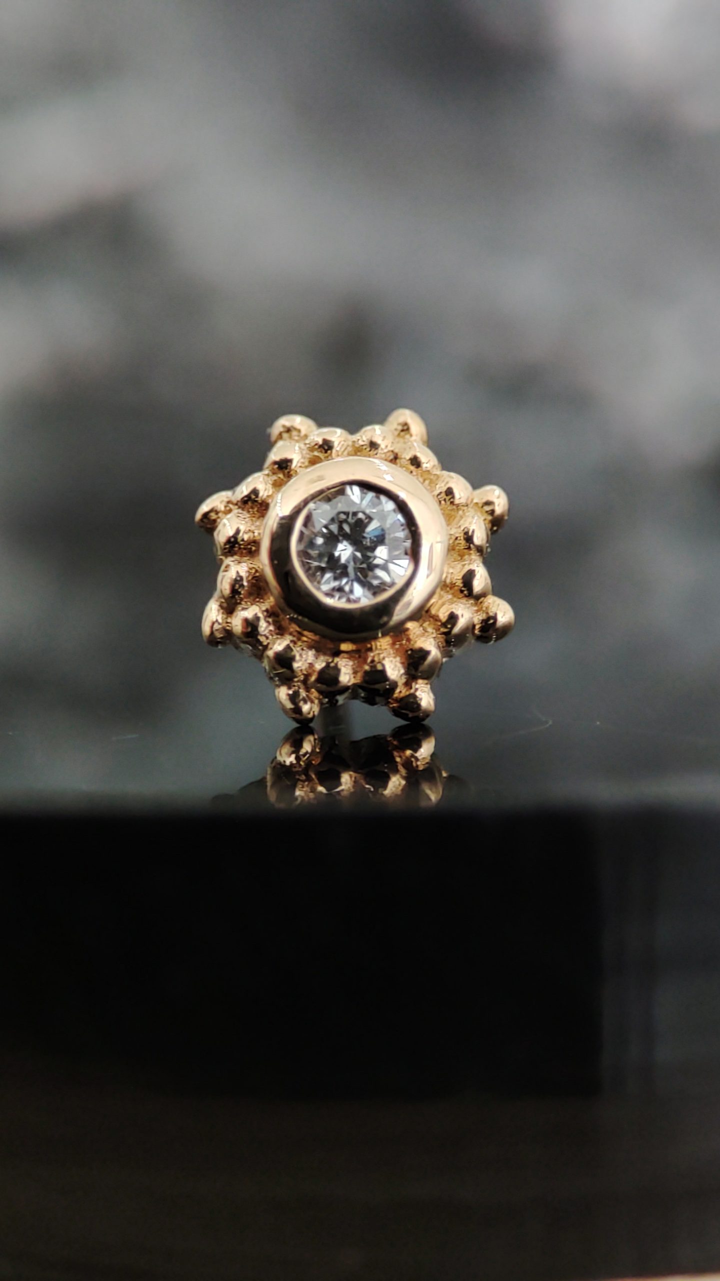 NAGA Peshavia White Diamond – pirsing nakit od 18K zlata NAGA Peshavia White Diamond – zlatni pirsing nakit sa svetlucavim belim kamenom i dekorativnim detaljima